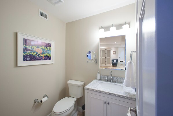 Une salle de bain avec des toilettes, un lavabo et un tableau encadré au mur.