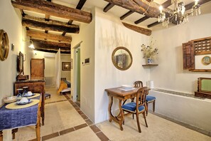 Experience the perfect blend of traditional charm and modern style in this beautifully appointed room, featuring a dining area, chandelier, and framed artwork.