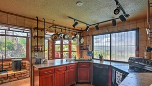 A kitchen with a large island, hanging pots, and a stove. - Tropical Ponce Home: Private Pool & Outdoor Oasis! (Ponce)