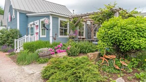 A charming house with a porch, a garden with flowers and plants, and a bicycle. - Fresh Powder: Modern Style Near Sugarbush! (Warren)
