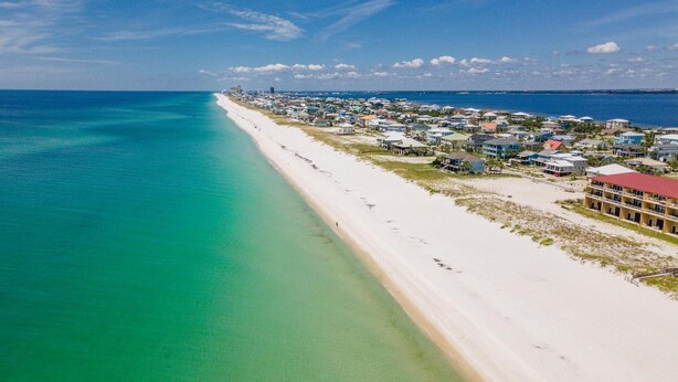 A coastal town with a long sandy beach and a row of houses along the shore. - Gorgeous Gulf View Home with Private Pool! Pet friendly too! (Pensacola Beach)