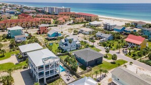A coastal residential area with various houses, some with pools, and a beach in the background. - Gorgeous Gulf View Home with Private Pool! Pet friendly too! (Pensacola Beach)