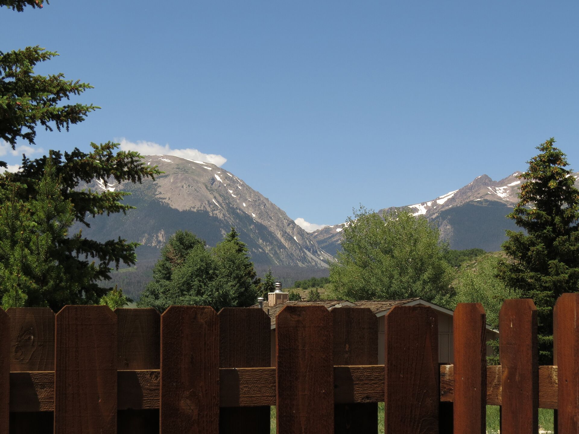 A wooden fence with a mountain backdrop.