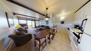 Enjoy meals and relaxation in this spacious living area with a dining table, comfortable seating, and a fireplace.