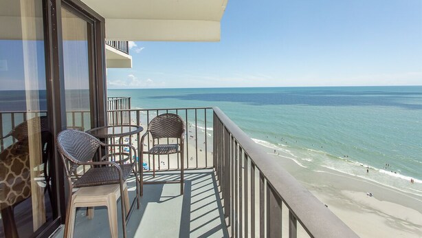 Un balcon avec vue sur la plage et l’océan.