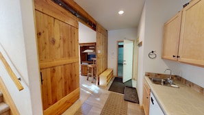 A kitchen with wooden cabinets, a sink, and a countertop. - Private Hot Tub, Lift Chairs. On River Rec Trail. Easy Drive to Dine, Shop (Silverthorne)