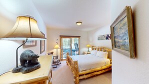 A cozy room with a bed, a desk, a lamp, and a bear statue. - Private Hot Tub, Lift Chairs. On River Rec Trail. Easy Drive to Dine, Shop (Silverthorne)