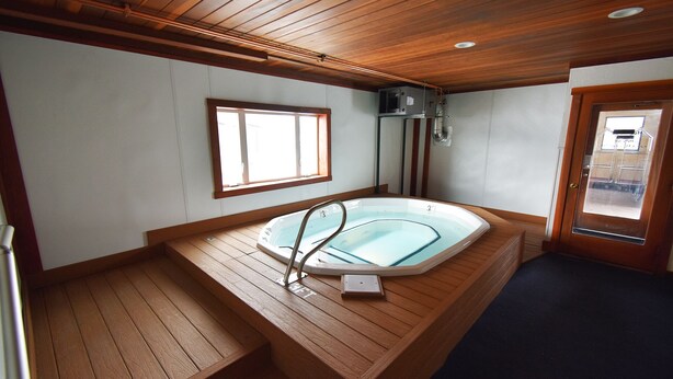 A wooden deck with a hot tub, a window, and a door. - On Lake, Views! Hot Tub. Walk to Concerts, Marina, Dining. 1st Floor (Dillon)