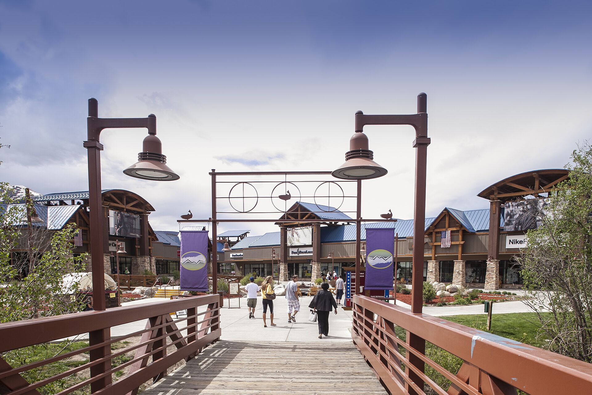 A wooden boardwalk leading to a building with a blue roof and a sign that reads "Fountain Ranch."