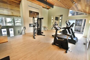 A gym with cardio equipment, a weight machine, and a large window.