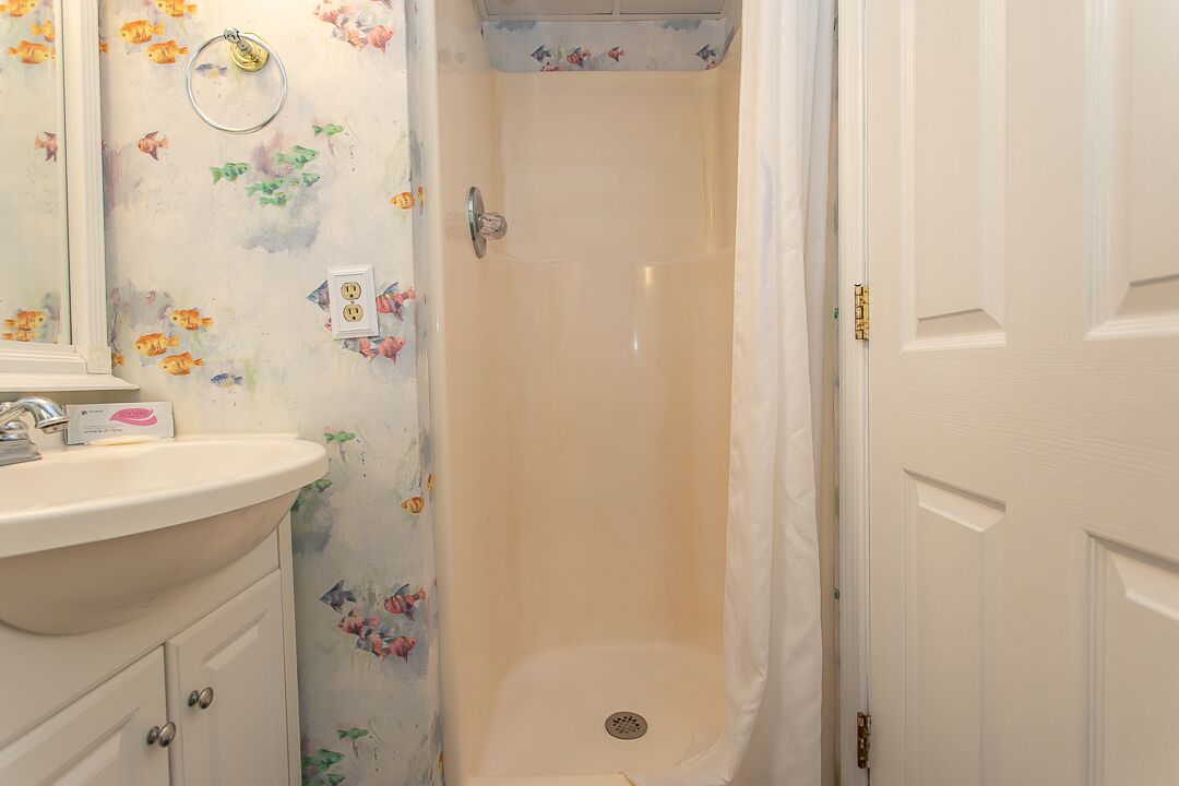 Un baño con lavabo, espejo y ducha.