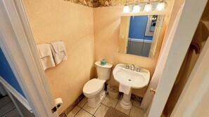 Un baño pequeño con inodoro, lavabo y espejo.