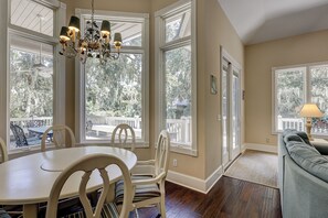 Enjoy a spacious room with a high ceiling, dining area, and seating area, offering a view of the outdoors through large windows.