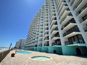 Un hôtel de grande hauteur doté de nombreux balcons, d’un espace piscine et offrant une vue sur la plage.