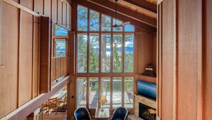 A spacious wooden interior with large windows, a fireplace, and a ceiling fan. - View at Dollar Point by Tahoe Getaways -  Lake Views in Tahoe City (Tahoe City)