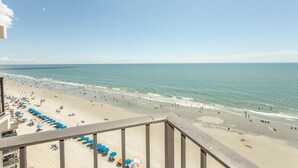 A beach with umbrellas and people. - NICE AND COMFY ONE BEDROOM OCEANFRONT IN FAMILY FRIENDLY RESORT (Murrells Inlet)