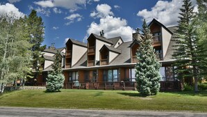 A lodge with multiple balconies and a stone facade, surrounded by trees and a clear sky. - Near Lake Dillon! 3 Kings. Hot Tub, Yard. On Rec Path, Near Dining, Shops (Keystone)