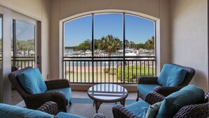 A balcony with wicker furniture, a glass table, and a view of a marina with boats. - 2 Bedroom/2.5 Bathroom Well Kept Bright Villa - Gated Complex - Harbour Views (Hilton Head Island)