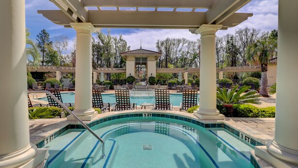 A pool area with a pergola, lounge chairs, and a building in the background. - 2 Bedroom/2.5 Bathroom Well Kept Bright Villa - Gated Complex - Harbour Views (Hilton Head Island)