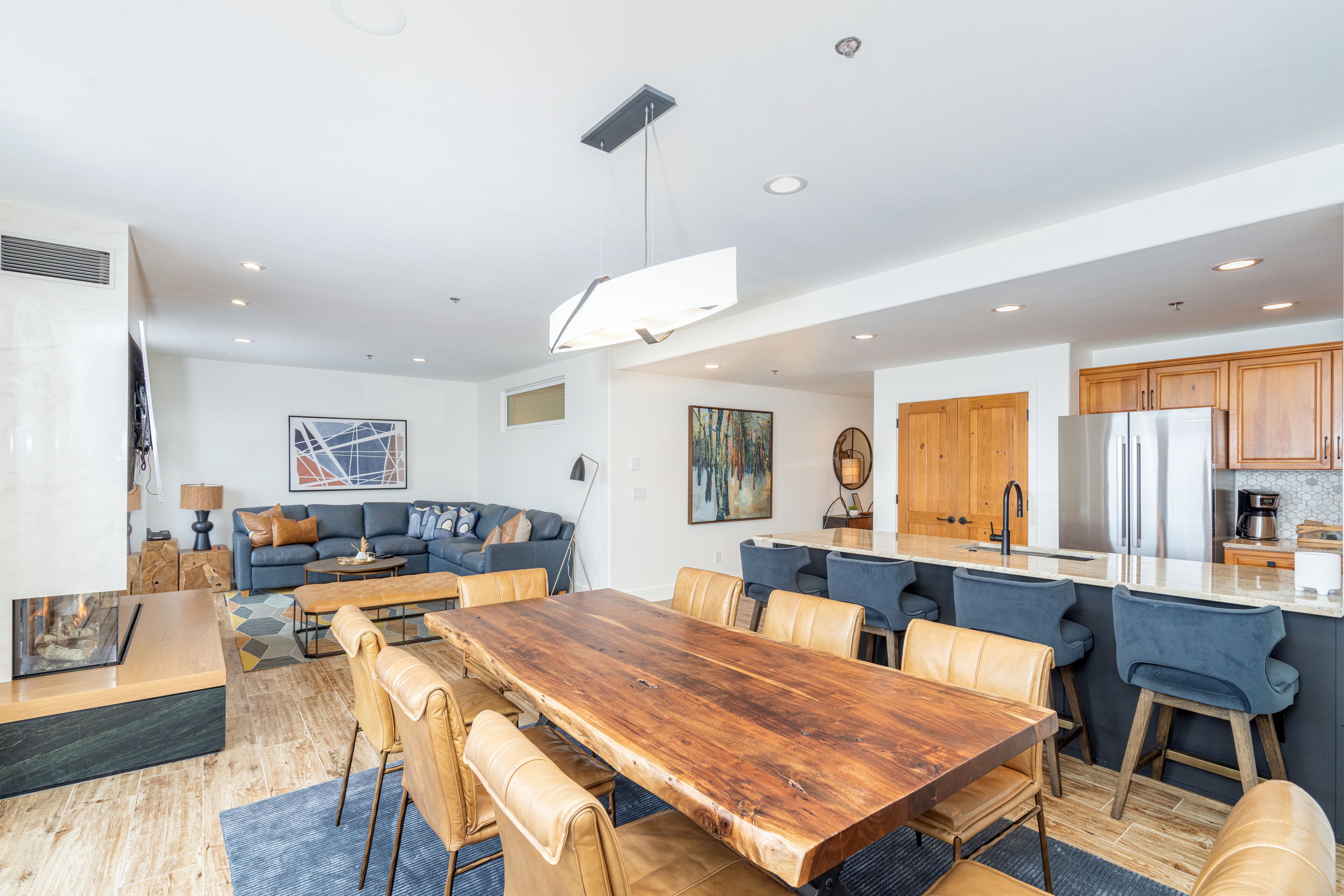 Une cuisine moderne dotée d’un îlot central, de meubles en bois et d’un réfrigérateur en acier inoxydable.