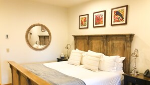 A bedroom with a wooden bed, a round mirror, and three framed artworks on the wall. - Quiet Lock-Off Room With King Bed in Mountain Village (Mountain Village)