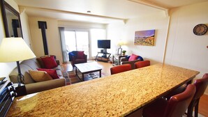 A spacious living area with a large kitchen island, a television, and a dining table. - On Lake! Views, 1st Floor, Hot Tub! Walk to Amphitheater, Marina, Dining (Dillon)