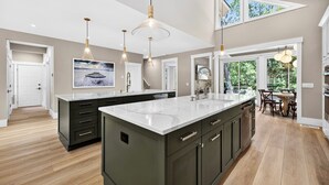 A modern kitchen with a large island, pendant lighting, and a view of the outdoors. - Stunning fourth row home in Palmetto Dunes with pool & spa- Beach path nearby (Hilton Head Island)