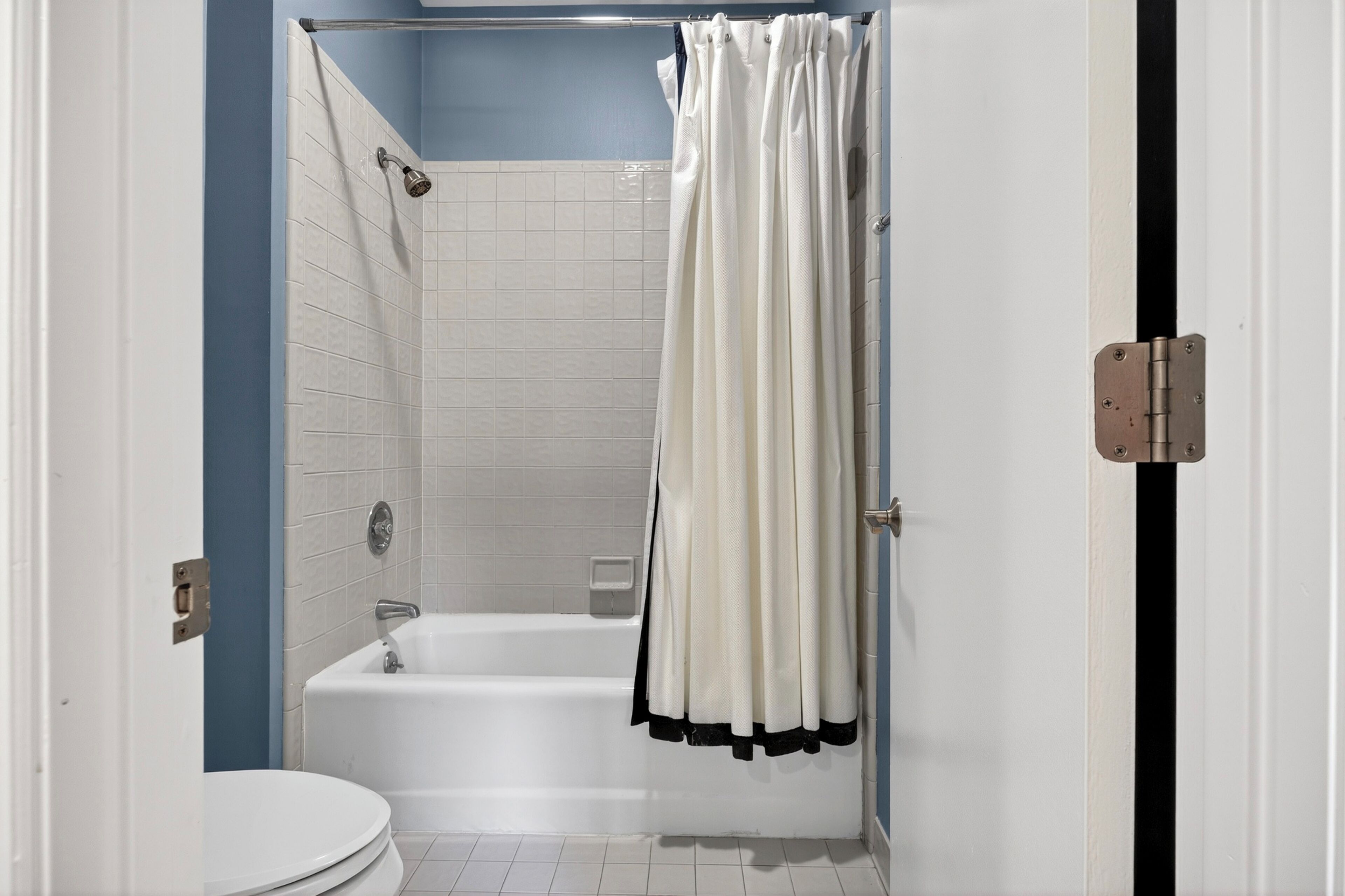 Un baño con bañera, inodoro y cortina de ducha.