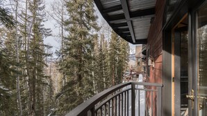 A balcony with a view of tall pine trees and a mountain in the background. - Private Forest Views in Spacious 3-Bedroom Condo (Mountain Village)