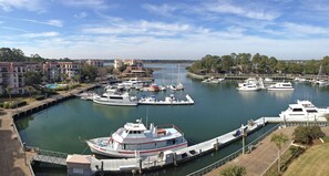 Boats docked at the marina, adjacent to residential buildings with balconies, connected by a bridge.