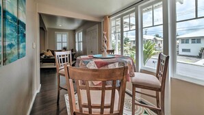 A dining area with a round table covered by a colorful tablecloth, surrounded by wooden chairs. - Hawaiian Hideaway w/ Yard < 2 Miles to Hilo Bay! (Hilo)