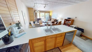 Una cocina moderna con armarios de madera, una encimera blanca y un lavavajillas integrado.