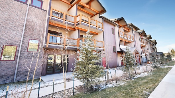 A multi-story building with balconies, a brick facade, and a clear sky. - AC! On River Trail. Walk to Dining, Shops, Events, Theater, Weddings (Silverthorne)