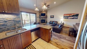 A modern kitchen with a stone backsplash, a built-in dishwasher, and a large island. - AC! On River Trail. Walk to Dining, Shops, Events, Theater, Weddings (Silverthorne)