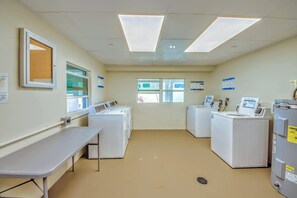 A laundry facility with multiple washing machines, a drying rack, and a sink. - Gateway Villas #199 Lovely Beachfront Condo (Fort Myers Beach)