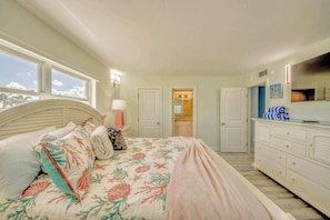 A bedroom with a bed, dresser, and a bathroom visible through an open door. - Gateway Villas #199 Lovely Beachfront Condo (Fort Myers Beach)