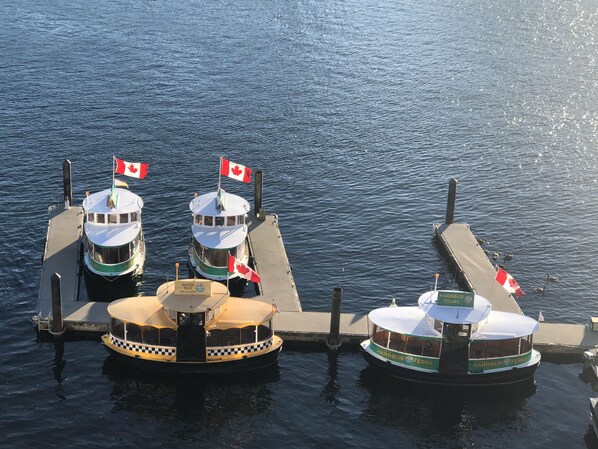 Three boats docked at a pier with Canadian flags.