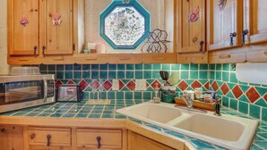 A kitchen with wooden cabinets, a microwave, a toaster, and a sink with a tiled backsplash. - 6 Mi to Texas Tech: Studio w/ Shared Pool & Grill (Lubbock)