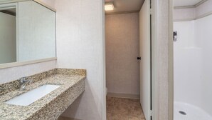 A bathroom with a granite countertop sink, a mirror, a shower, and a toilet. - Room With Kitchenette for Budget Travelers (Telluride)