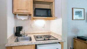 A compact kitchen with a microwave, coffee maker, and a small dishwasher. - Updated Hotel Room With Kitchenette, Seating Area at the Mountainside Inn (Telluride)