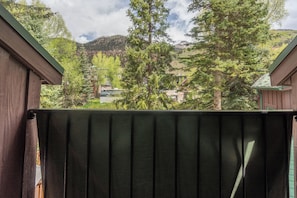 A wooden balcony with a view of a mountainous landscape and a house in the distance. - Get An Authentic Telluride Experience in This Classic Ski Chalet Room (Telluride)