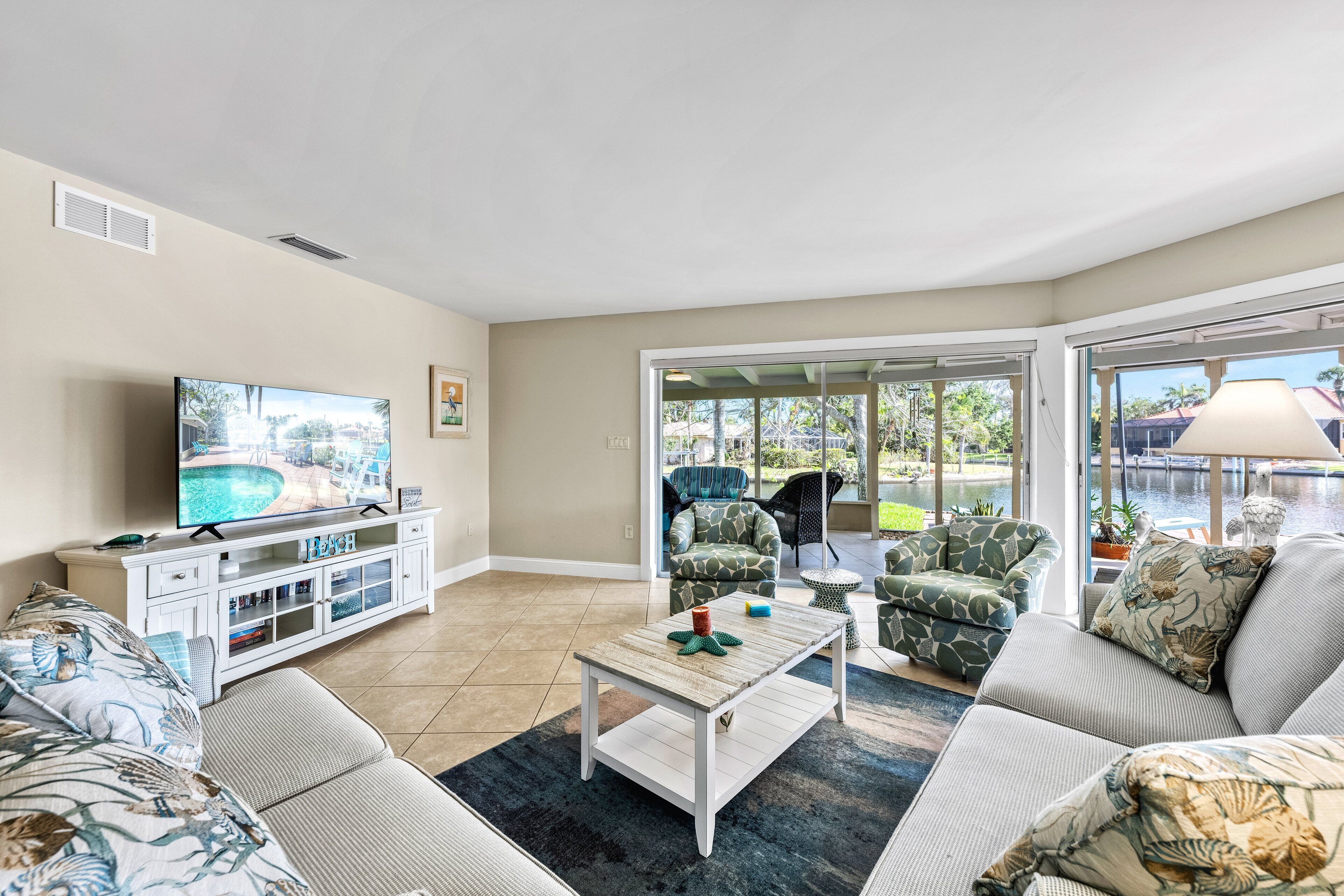 A living room with a television, a coffee table, and seating.