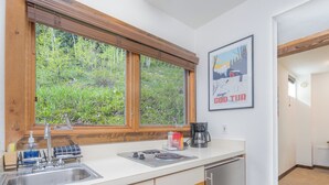Eine Küche mit Fenster, Kaffeemaschine und Spüle.