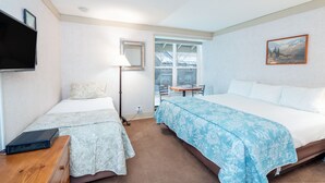 A hotel room with two beds, a TV, a desk, and a window with a view of buildings. - Affordable, Slopeside, In Town - It Doesn't Get Any Better Than This (Telluride)