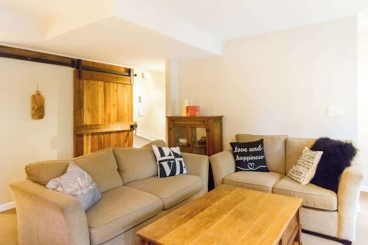 Un salon avec deux canapés, une table basse en bois et un meuble en bois.