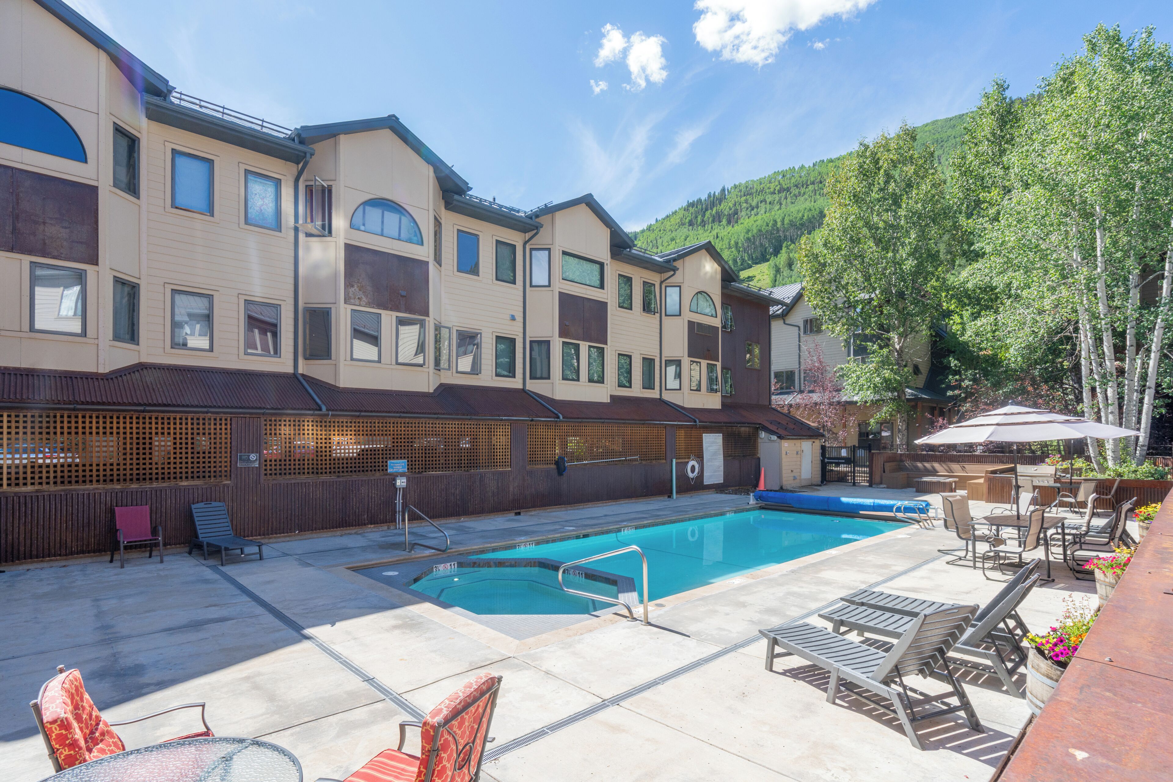 A pool area with lounge chairs and a barbecue setup.