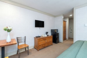 Cozy living space with a dresser, TV, and comfortable seating area.