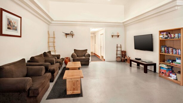 Una sala de estar moderna con sofás, una mesa de centro, una estantería, un televisor y una guitarra.