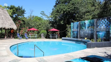 Alberca al aire libre y camastros