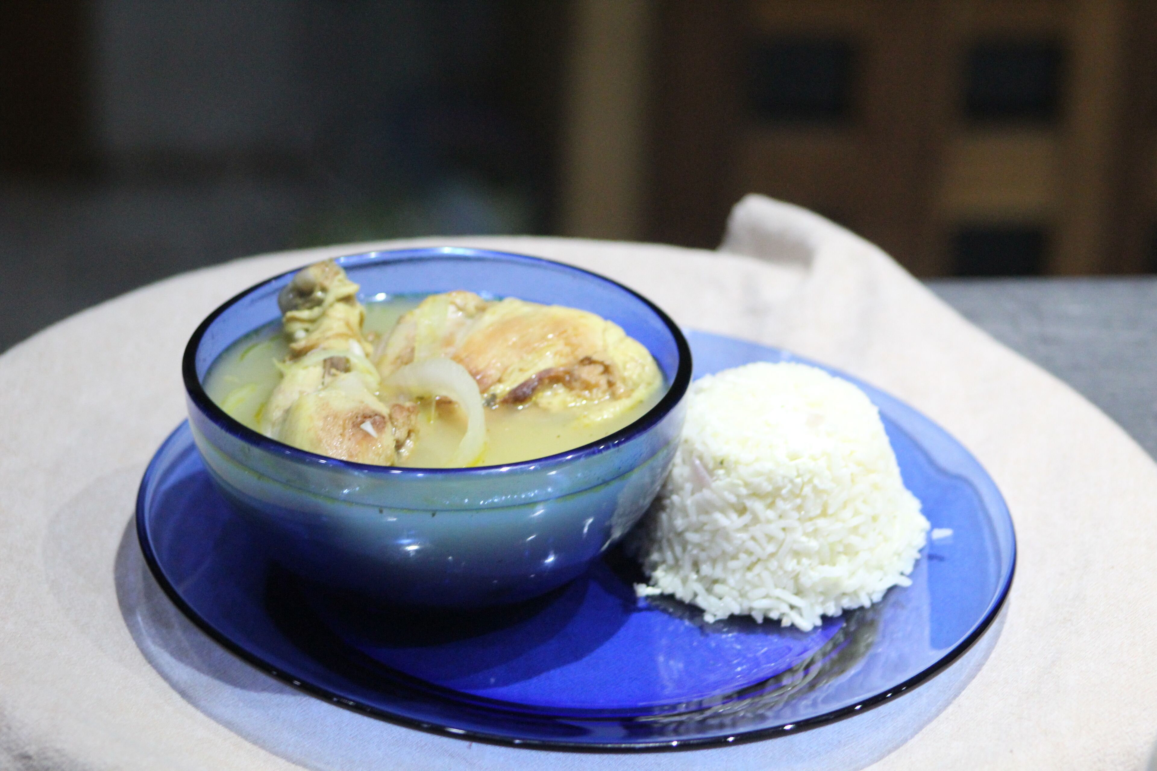 A blue bowl with a white rice dish on a white plate.